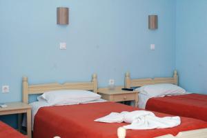 two beds in a room with blue walls at Hotel Paros in Parikia