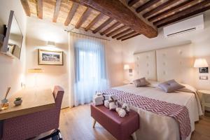 een slaapkamer met een groot bed en een bureau bij Hotel Il Palazzo in Assisi