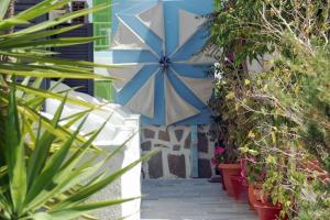 a blue and white umbrella on a house with plants at Hotel Paros in Parikia