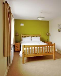 a bedroom with a bed and a green wall at Bunratty Holiday Homes in Bunratty