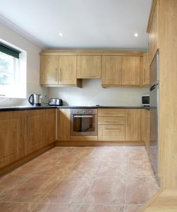 a kitchen with wooden cabinets and stainless steel appliances at Bunratty Holiday Homes in Bunratty