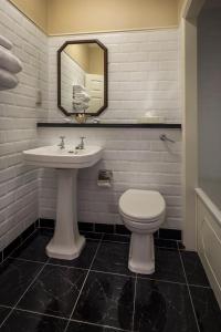 a bathroom with a sink and a toilet and a mirror at Imperial Hotel Cork City in Cork