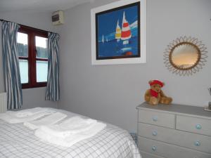 a bedroom with a bed and a teddy bear on a dresser at The Den in Egloskerry