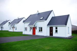 Une rangée de maisons blanches avec une porte rouge dans l'établissement Burren Way Cottages, à Ballyvaughan