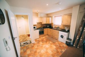a kitchen with wooden cabinets and a tile floor at City centre penthouse apartment in Belfast