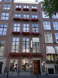 un edificio de ladrillo con ventanas y flores. en Hotel Hoksbergen, en Ámsterdam