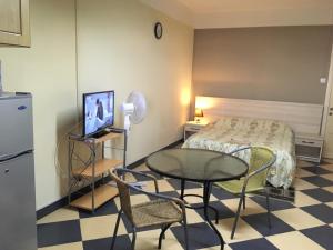 a small room with a table and a bed at Br Court Apartments in Quatre Bornes