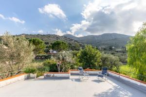 eine Terrasse mit zwei Stühlen und Bergen im Hintergrund in der Unterkunft Villa Violetta in Carini