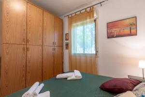 カリーニにあるVilla Violettaのベッドルーム1室(緑のベッド1台、木製キャビネット付)