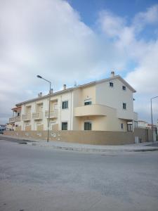 a large white building on the side of a street at The Beach House in Figueira da Foz