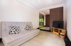 بيلا كيتا ماونتن ريتريت آند سبا في Klungkung: غرفة معيشة مع أريكة وتلفزيون بشاشة مسطحة