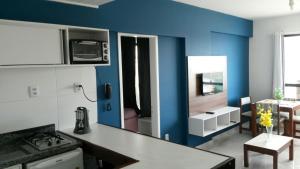 a kitchen with a blue wall and a counter top at Apartamento temporada Farol Barra Flat in Salvador