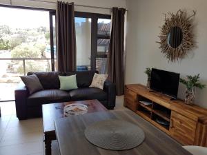 uma sala de estar com um sofá e uma mesa em Rieks van der Walt Self-Catering Apartment em Windhoek