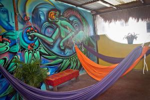 Zimmer mit 2 Hängematten vor einem Wandbild in der Unterkunft Tres Mundos Hostel in Playa del Carmen