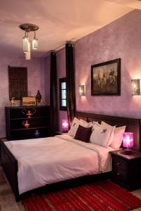 ワルザザートにあるRiad Ksar Aylanの紫の壁のベッドルーム1室(大型ベッド1台付)