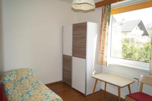 Schlafzimmer mit einem Bett, einem Tisch und einem Fenster in der Unterkunft Haus Kollin in Keutschach am See