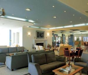 格雷韋納州的住宿－Hotel Αchillion Grevena，客厅配有沙发、椅子和桌子