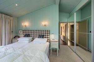 a bedroom with a large white bed and blue walls at Aberdaron Lodge in Aberdaron