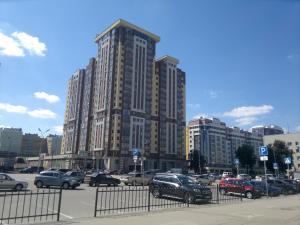 リャザンにあるЦентр города 124 Апартаменты с балконом Вокзальная 77の高層ビルの前に車を停めた駐車場