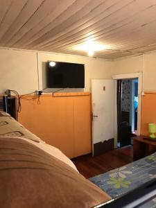 a bedroom with a bed and a flat screen tv at Hospedaje Freire in Osorno