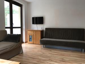a living room with a couch and a flat screen tv at Nowa Apartamenty Apartament Słoneczny Bulwar in Krynica Morska