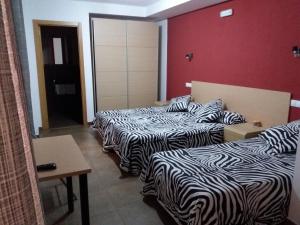 a hotel room with two beds and a desk at Hostal la Catedral in Santo Domingo de la Calzada