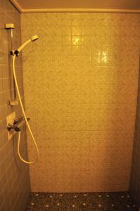 a shower with a hose in a bathroom at Suldal Hotell in Sand
