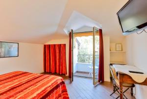 Schlafzimmer mit einem Bett, einem Schreibtisch und einem Fenster in der Unterkunft Cà De Rossana Bed&Breakfast in Sanremo