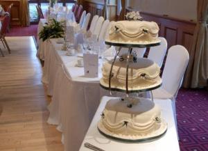 Uma fila de mesas com bolos de casamento. em Upton Court Hotel em Kilmuckridge