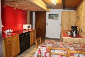 a kitchen with red walls and a table with a microwave at Les Allamands in Morzine