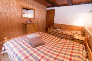 a bedroom with two beds and a dresser at Les Allamands in Morzine