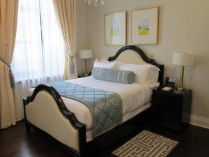 a bedroom with a bed with a blue pillow on it at Sydney Boutique Inn & Suites in Charlottetown
