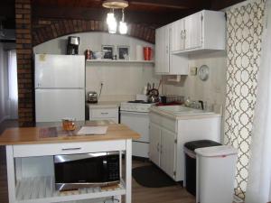 a kitchen with white cabinets and a counter with a microwave at Husky House in Bessemer