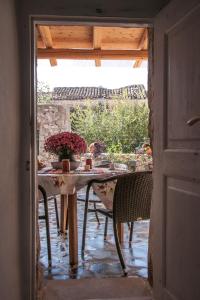 - une table avec des chaises et des fleurs sur la terrasse dans l'établissement Sophia Areopoli Guesthouse, à Areópoli
