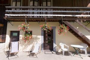 um pátio com cadeiras, uma mesa e flores em Maison de la coutetta em Morzine