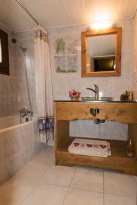 a bathroom with a sink and a mirror and a tub at Maison de la coutetta in Morzine