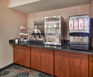 a coffee shop with a counter with a woman behind it at Cobblestone Inn & Suites - Big Lake in Big Lake
