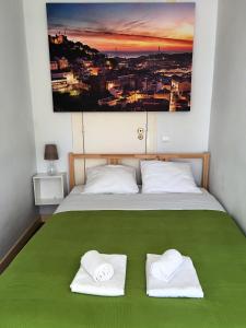 uma cama com duas toalhas brancas em cima em Casa do Meio em Lisboa