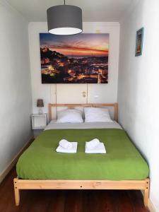 リスボンにあるCasa do Meioのベッドルーム1室(緑のベッド1台、タオル2枚付)