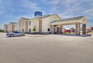 un edificio con un coche aparcado en un aparcamiento en Cobblestone Inn & Suites - Big Lake, en Big Lake