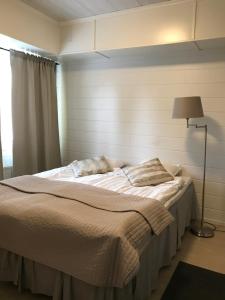 a large bed in a room with a lamp and a bed sidx sidx at E-City B&B in Tornio