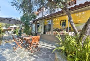 a patio with a table and chairs and an umbrella at Cà De Rossana Bed&Breakfast in Sanremo