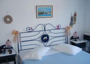 a bedroom with a blue bed and two night stands at Meltemi in Batsi