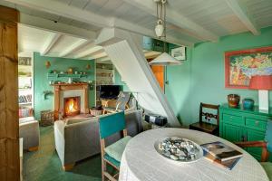 a living room with a table and a fireplace at Aberdaron Cottage 2 Bryn Chwilog in Aberdaron