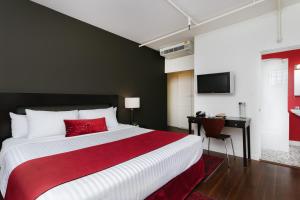 a bedroom with a red and white bed and a desk at Moda Hotel in Vancouver