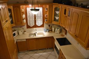 a kitchen with wooden cabinets and a sink and a window at Anna's Villa Portaria in Portaria