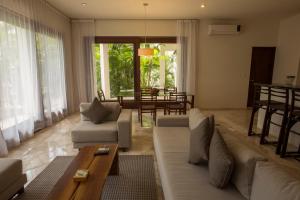 sala de estar con sofá y mesa en Intima Resort Tulum Adults Only (Clothing Optional), en Tulum