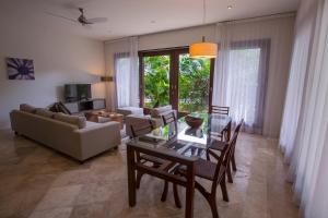 a living room with a table and chairs and a couch at Intima Resort Tulum Adults Only (Clothing Optional) in Tulum