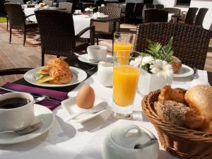 einen Tisch mit Teller mit Speisen und Orangensaft in der Unterkunft AVITAL Resort in Winterberg