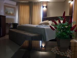 een woonkamer met een bank en een tafel met een vaas met bloemen bij Hotel Itatiaia in Tangara da Serra